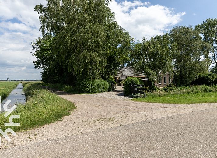 Zonnig terras bij OV529 vakantiehuis in Zwolle, Salland, met houten picknicktafel.