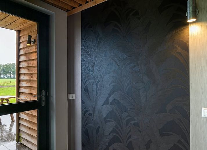 Gezellige woonkamer in Vakantiehuisje in Heeten, Salland, met open keuken en houten plafond.