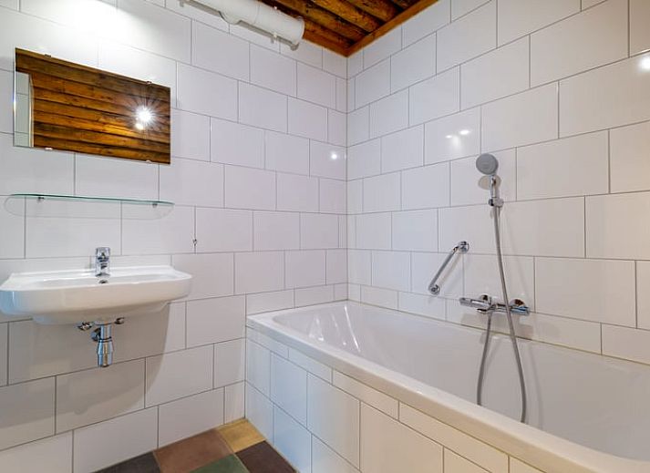 Gezellige woonkamer in Vakantiehuisje in Heeten, Salland, met open keuken en houten plafond.