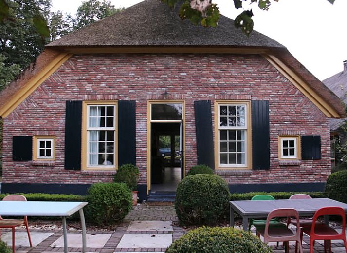Charming cottage in Heeten, Salland with an inviting brick facade and green garden.