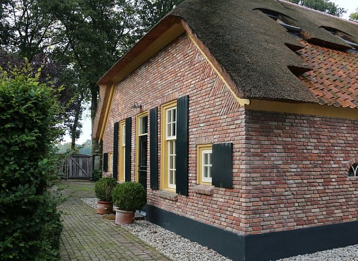 Charming cottage in Heeten, Salland with an inviting brick facade and green garden.