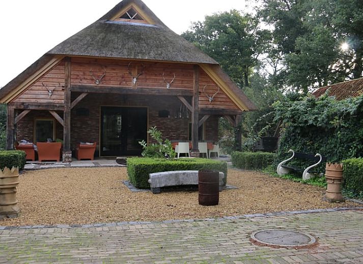 Charming cottage in Heeten, Salland with an inviting brick facade and green garden.