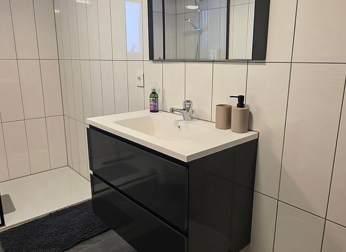 Gemuetliches Schlafzimmer im Huisje in Olst, einem Ferienhaus in Olst, Salland, Overijssel, mit Holzwaenden und einem bequemen Bett.