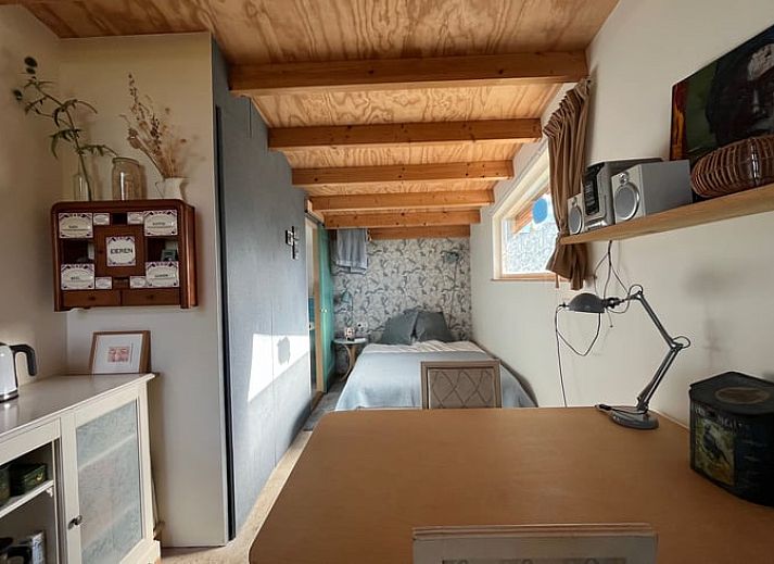 Gemuetlicher Innenbereich des Ferienhauses in Olst, Salland mit Holzdecke und bequemer Sitzecke.