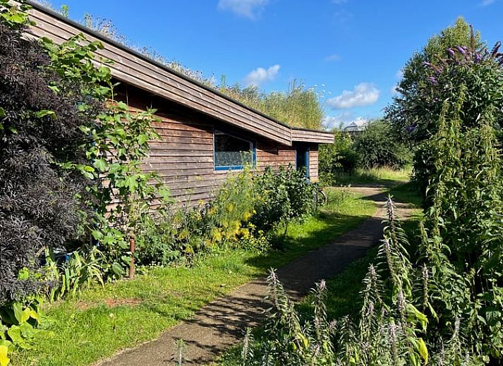 Offener Durchgang zum Schlafzimmer im Ferienhaus in Olst, mit Blick auf einen gruenen Garten.
