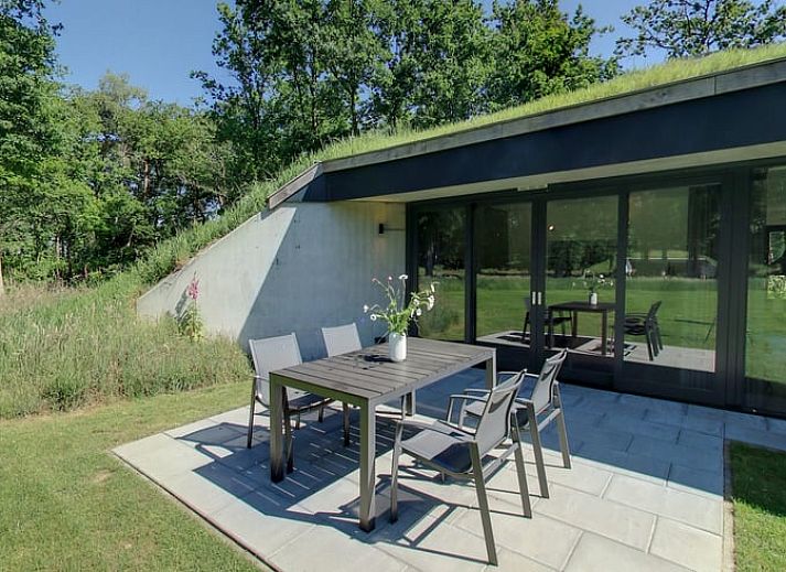 Gezellige woonkamer in Vakantiehuis in Hellendoorn, Salland, met uitzicht op groene omgeving en moderne inrichting.