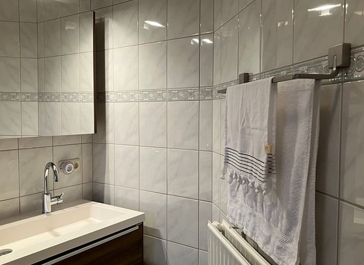 Gemuetliche Kueche in Cottage in Hellendoorn, Ferienhaus in Hellendoorn, Overijssel mit Holztisch und rosa Stuehlen.