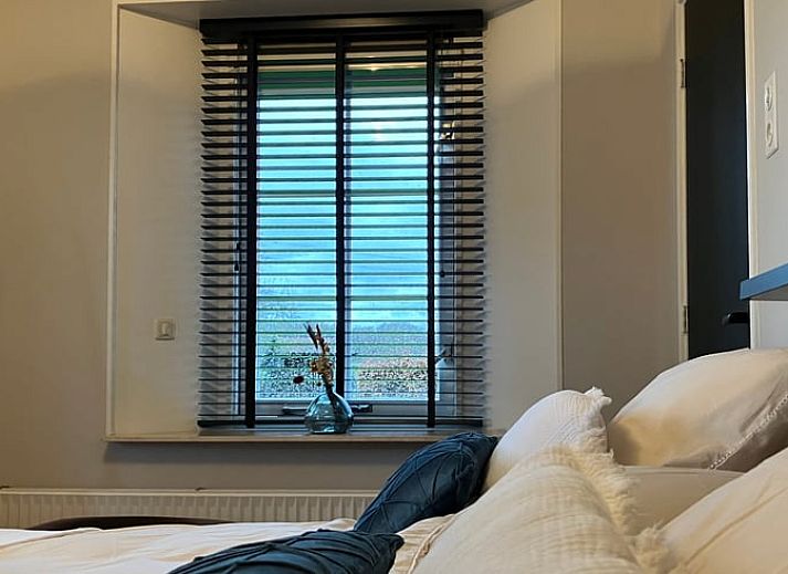 Gemuetliche Kueche in Cottage in Hellendoorn, Ferienhaus in Hellendoorn, Overijssel mit Holztisch und rosa Stuehlen.