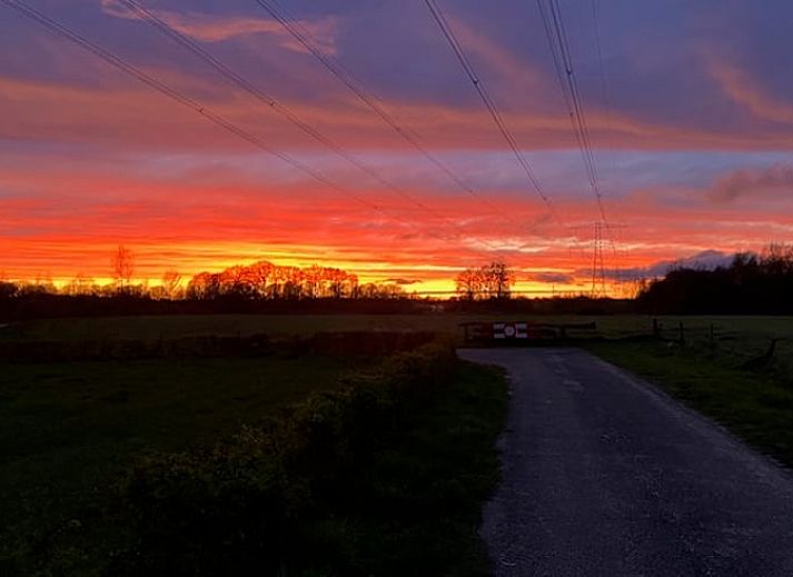 Gemuetliches Esszimmer in Cottage in Hellendoorn, Ferienhaus in Hellendoorn, Overijssel, mit rundem Tisch und Blick auf die gruene Umgebung.