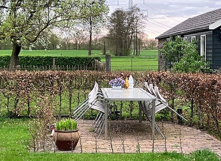 Gemuetliches Wohnzimmer in Cottage in Hellendoorn, einem Ferienhaus in Hellendoorn, Overijssel, mit bequemen Stuehlen und moderner Einrichtung.