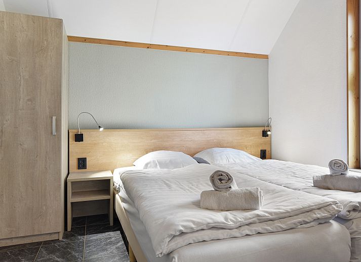 Gezellige slaapkamer in Landgoed De Hellendoornse Berg kinderbungalow, Haarle, Overijssel, met comfortabele bedden.