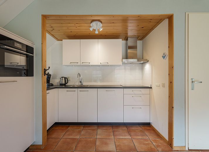 Knusse zithoek in Landgoed De Hellendoornse Berg kinderbungalow, Haarle, Overijssel, met wijn en glazen.