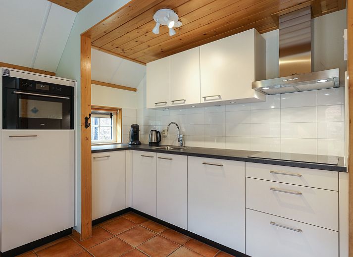 Knusse zithoek in Landgoed De Hellendoornse Berg kinderbungalow, Haarle, Overijssel, met wijn en glazen.