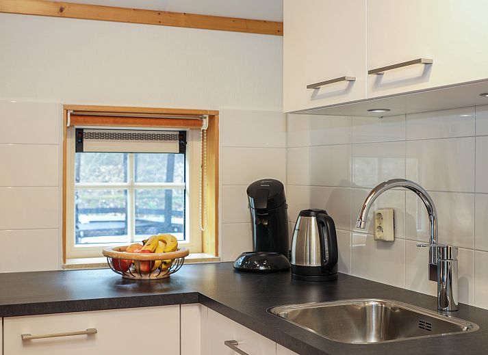 Knusse zithoek in Landgoed De Hellendoornse Berg kinderbungalow, Haarle, Overijssel, met wijn en glazen.