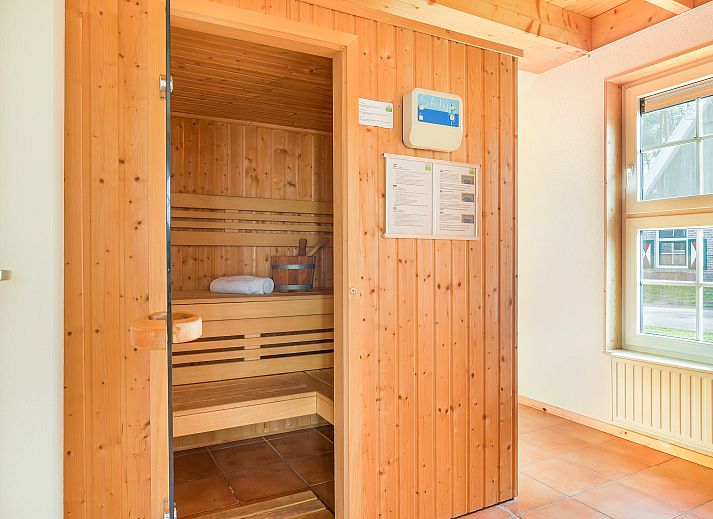 Essbereich im Landgoed De Hellendoornse Berg Bungalow Notar, Haarle, mit Holzmoebeln und viel Licht.