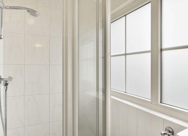 Gezellige woonkamer in Landgoed De Hellendoornse Berg bungalow, Haarle, met uitzicht op de tuin.