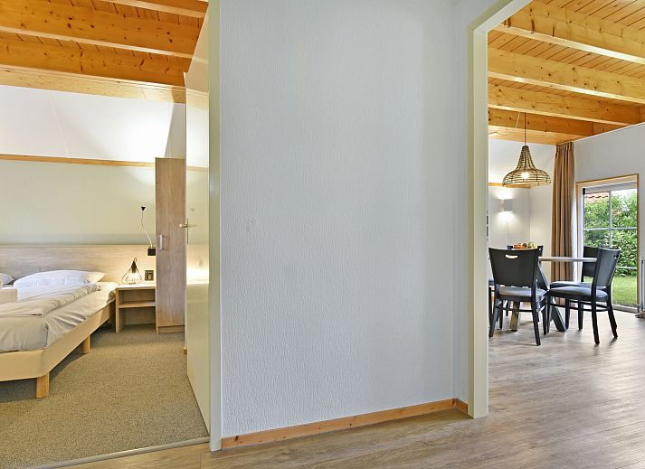 Gezellige woonkamer in Landgoed De Hellendoornse Berg bungalow, Haarle, met uitzicht op de tuin.