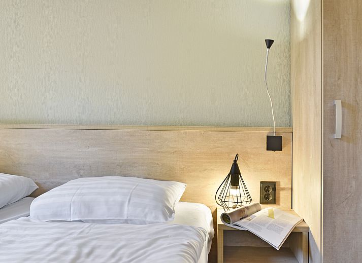 Gezellige woonkamer in Landgoed De Hellendoornse Berg bungalow, Haarle, met uitzicht op de tuin.