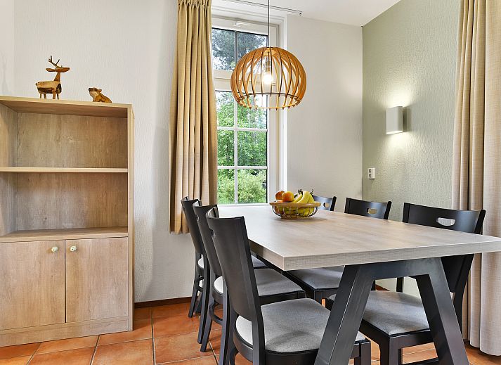 Ruime woonkamer met houten balken in 6-persoons bungalow op Landgoed De Hellendoornse Berg, Haarle.