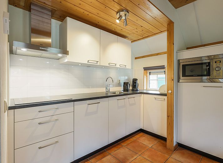 Ruime woonkamer met houten balken in 6-persoons bungalow op Landgoed De Hellendoornse Berg, Haarle.