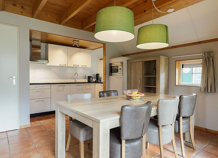 Ruime woonkamer met houten balken in 6-persoons bungalow op Landgoed De Hellendoornse Berg, Haarle.