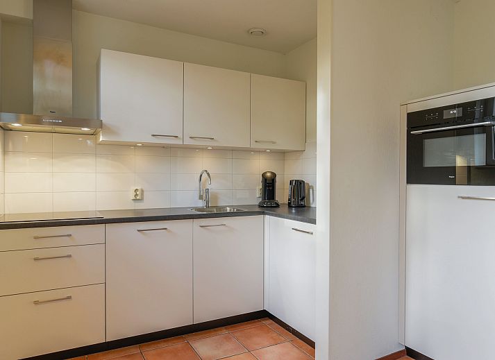 Eethoek en keuken in Landgoed De Hellendoornse Berg bungalow, ideaal voor familiediners in Haarle.