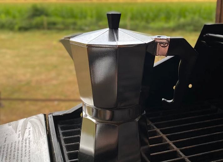Charmant vakantiehuisje in Wesepe, Salland, Overijssel omringd door natuur met houten veranda en zitplek voor een ontspannen verblijf.