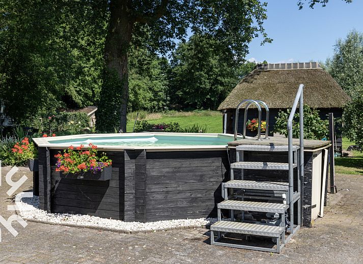 Gemuetliche Leseecke im Ferienhaus OV599 in Nieuw-Heeten, Salland, Overijssel mit Buecherregalen und Pflanzen.