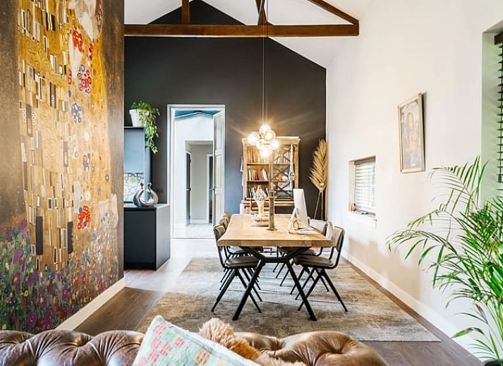 Stijlvolle woonkamer in Vakantiehuis in Diepenveen, met comfortabele zithoek en uitzicht op de groene omgeving.