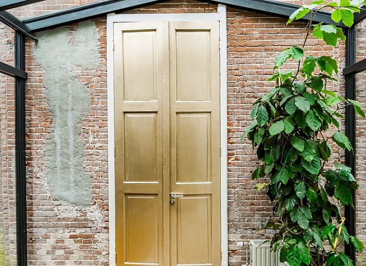 Stijlvolle woonkamer in Vakantiehuis in Diepenveen, met comfortabele zithoek en uitzicht op de groene omgeving.