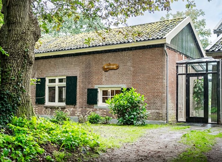 Stijlvolle woonkamer in Vakantiehuis in Diepenveen, met comfortabele zithoek en uitzicht op de groene omgeving.