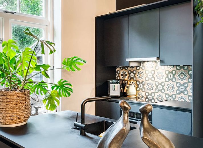 Stijlvolle woonkamer in Vakantiehuis in Diepenveen, met comfortabele zithoek en uitzicht op de groene omgeving.