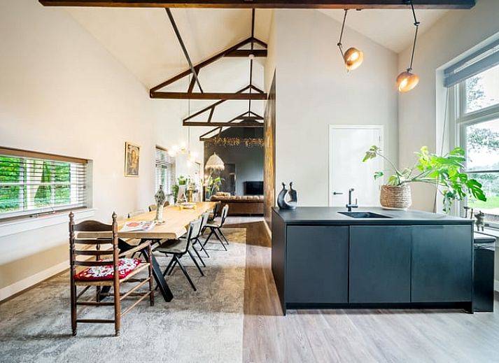 Stijlvolle woonkamer in Vakantiehuis in Diepenveen, met comfortabele zithoek en uitzicht op de groene omgeving.