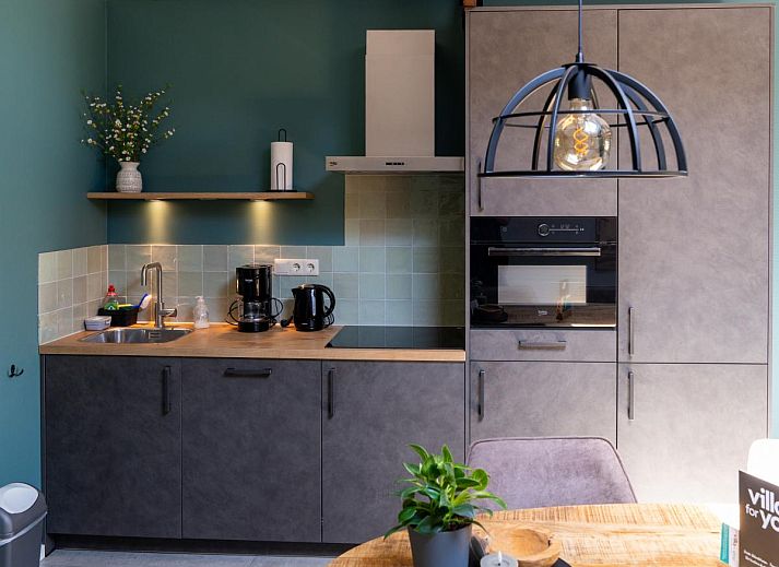 Sonnige Terrasse am Ferienhaus Regge en Weidezicht in Marle, Salland, Overijssel, umgeben von bluehenden Pflanzen.