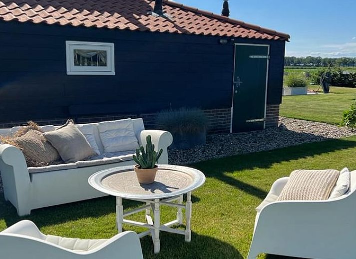 Gezellige woonkamer in Vakantiehuis in Ommen, Vechtstreek, Overijssel met modern interieur en uitzicht op de tuin.
