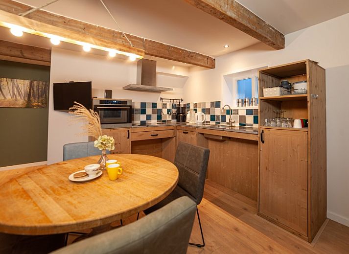 Terras van De Bosuil in Punthorst, Vechtstreek, met kleurrijke bloemen en comfortabele zitgelegenheid.