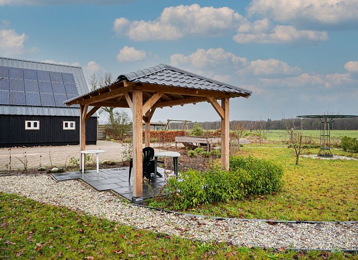 Natuurrijke omgeving van De Bosuil vakantiehuis in Punthorst, Overijssel, met bloementuin en wandelpaden.