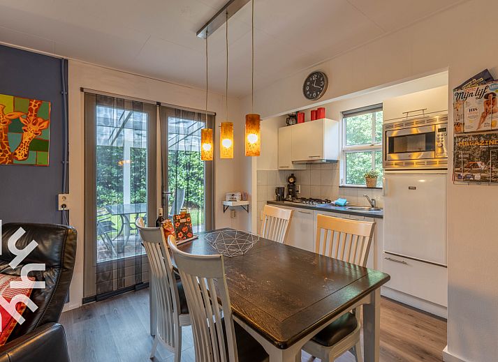 Gemuetliches Esszimmer im Ferienhaus OV260, Beerze, Vechtstreek mit moderner Kueche und Blick auf den gruenen Garten.