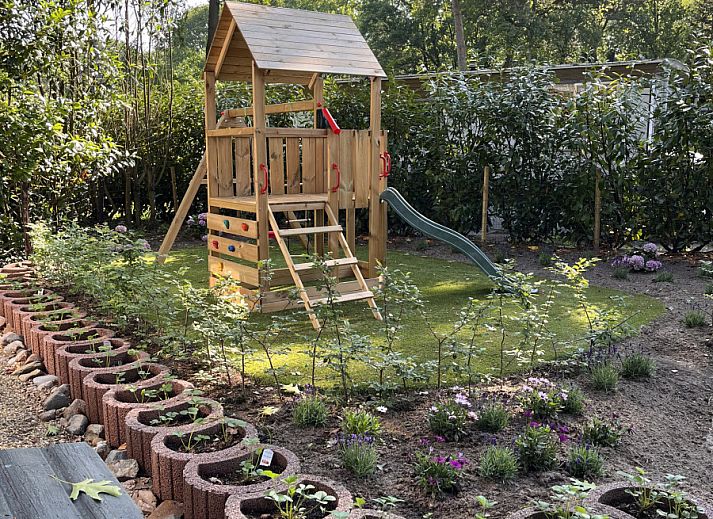 Gezellige veranda bij vakantiehuis OV703 in Beerze, Vechtstreek, Overijssel, met schommelstoel en tuinzicht voor ultieme ontspanning.