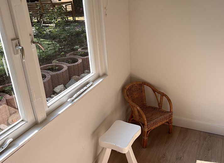 Gezellige veranda bij vakantiehuis OV703 in Beerze, Vechtstreek, Overijssel, met schommelstoel en tuinzicht voor ultieme ontspanning.