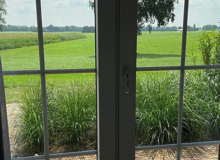 Modern living room in Holiday home in Dalfsen, Vechtstreek, Overijssel with comfortable chairs and stylish kitchen.