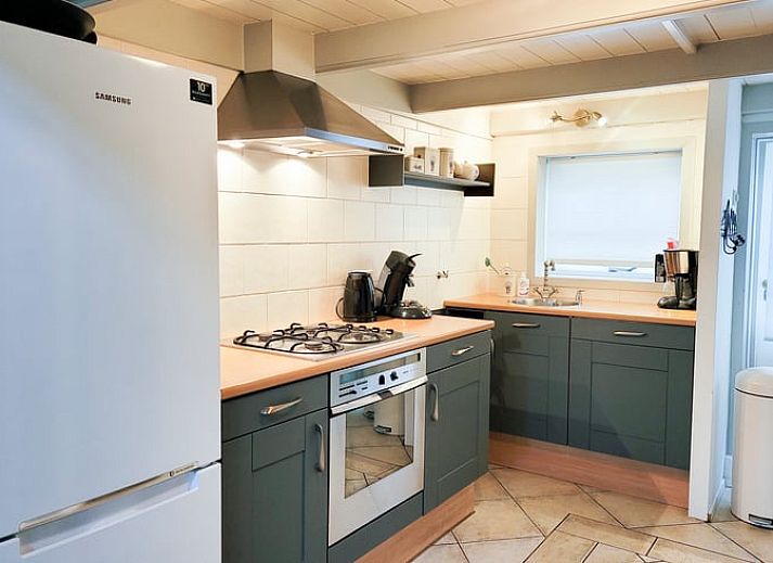 Gemuetliches Wohnzimmer von Huisje in Balkbrug, Ferienhaus in Vechtstreek, Overijssel mit geraeumiger Sitzecke und Holzinterieur.