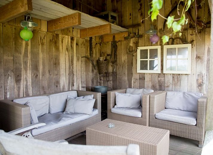 Gemuetliches Wohnzimmer von Huisje in Balkbrug, Ferienhaus in Vechtstreek, Overijssel, mit bequemen Ledersofas und Holzinterieur.