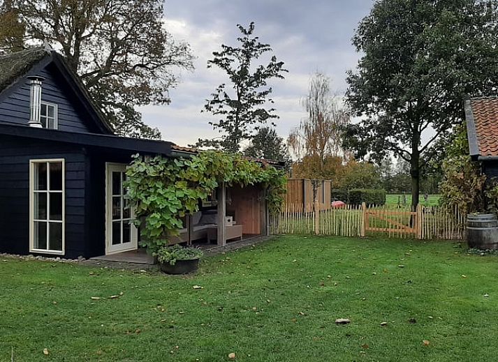Gemuetliches Wohnzimmer von Huisje in Balkbrug, einem Ferienhaus in der Region Vecht, Overijssel, mit bequemer Sitzecke und viel Tageslicht.