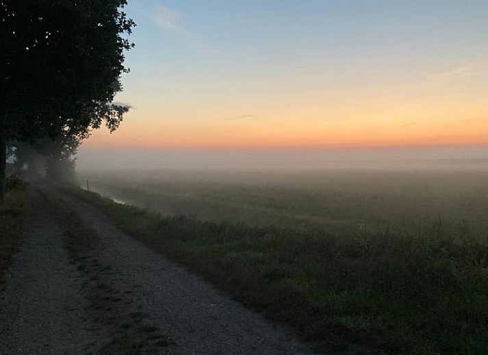 Gezellige binnenruimte van Vakantiehuisje in Balkbrug, Vechtstreek, Overijssel met houten muren en een blauwe tafel voor een knusse sfeer.
