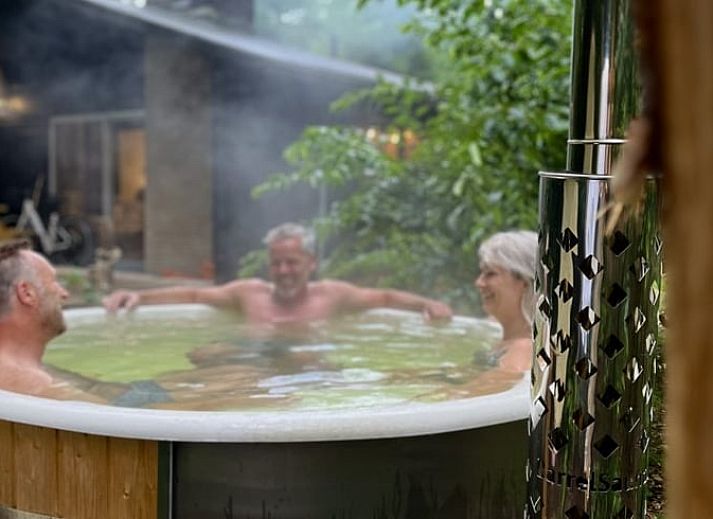 Eetkamer van Huisje in Rheezerveen met houten tafel en designlamp, gelegen in Vechtstreek, Overijssel.