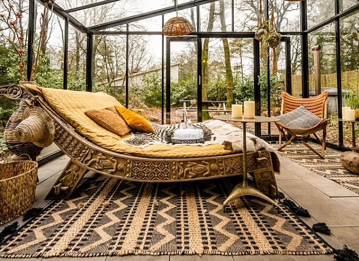 Gemuetlicher Wintergarten im Ferienhaus in Rheezerveen, Vechtstreek, Overijssel mit bequemen Liegestuehlen und Blick auf die Natur.