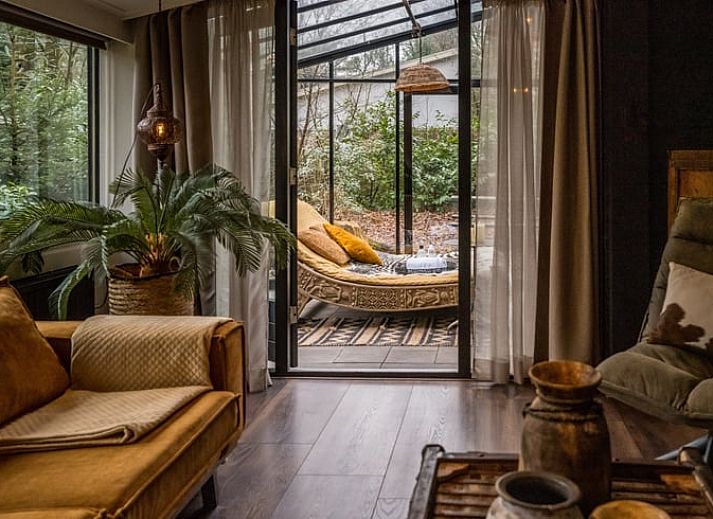 Gemuetlicher Wintergarten im Ferienhaus in Rheezerveen, Vechtstreek, Overijssel mit bequemen Liegestuehlen und Blick auf die Natur.