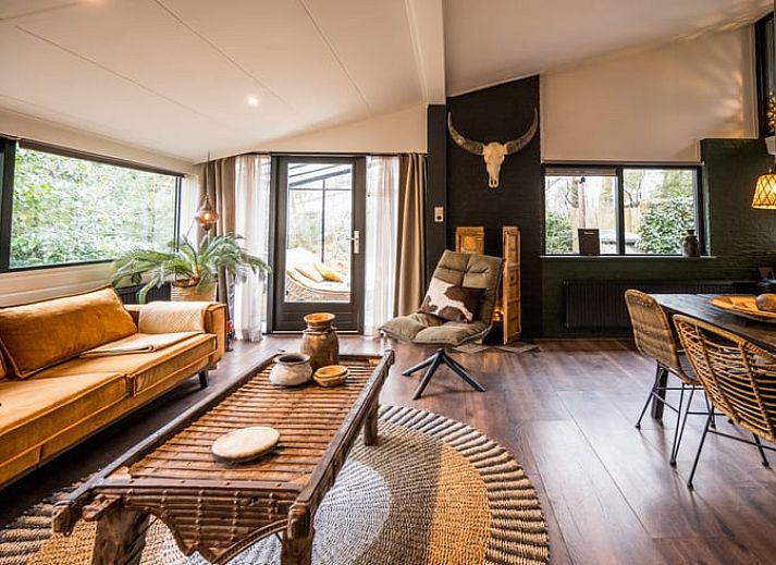 Gemuetlicher Wintergarten im Ferienhaus in Rheezerveen, Vechtstreek, Overijssel mit bequemen Liegestuehlen und Blick auf die Natur.