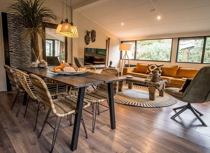 Stilvolles Wohnzimmer des Ferienhauses in Rheezerveen, Vechtstreek, Overijssel mit moderner Einrichtung und Zugang zum Wintergarten.